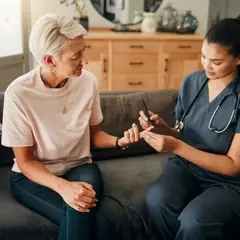Profissional de saúde conversando com uma mulher sobre a medição da glicemia